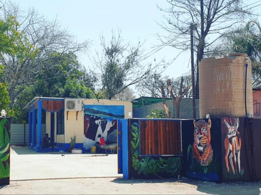 una cerca con pinturas al lado de una casa en P Wake Guesthouse, en Opuwo