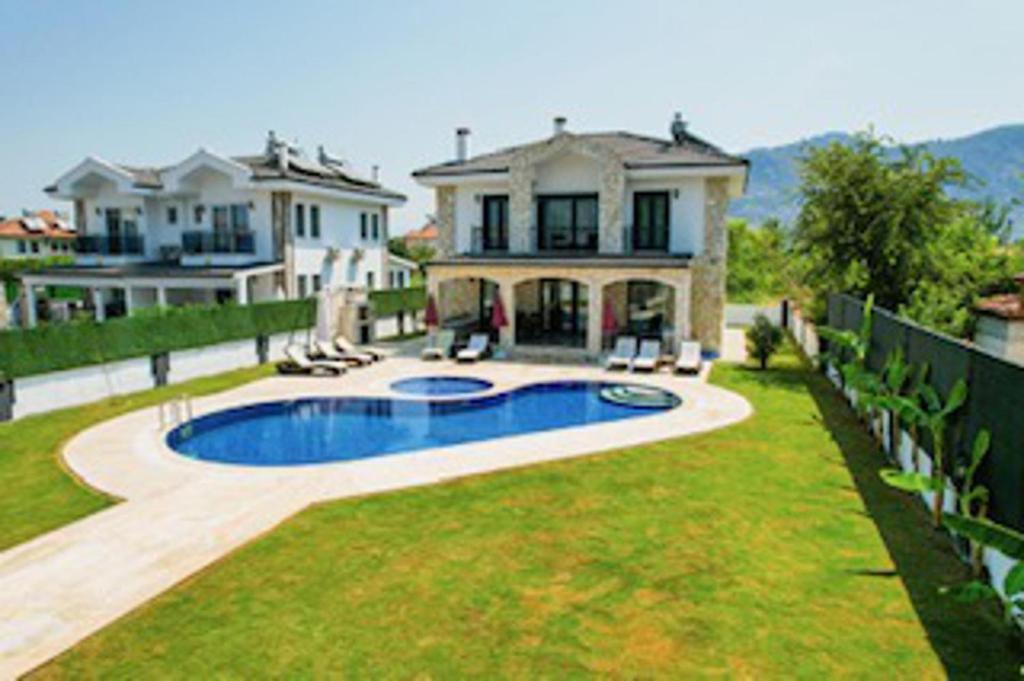 a large house with a swimming pool in the yard at Stunning 4 bedrooms Luxury Villa Kaan Dalyan in Dalyan