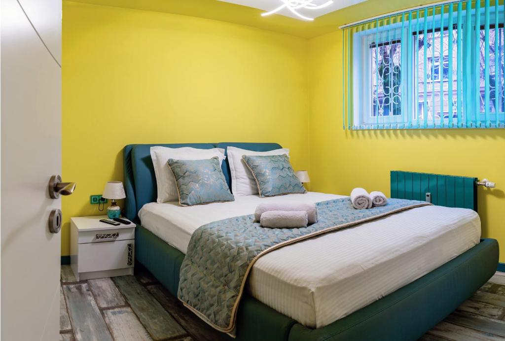 a bedroom with a bed with yellow walls at Sofiel cozy apartment - Top Center Sofia in Sofia
