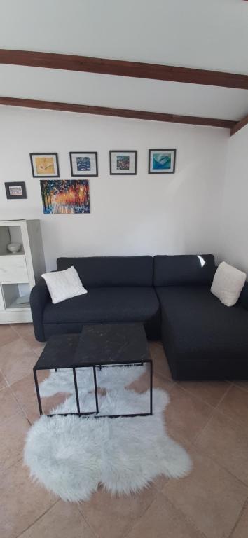 - un salon avec un canapé noir et une table dans l&#39;établissement Apartment Nika on the beach Mlini, à Mlini