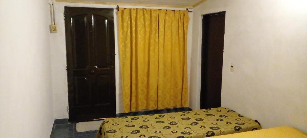 a bedroom with a bed and a window with a yellow curtain at Depto muy confortable in Corrientes