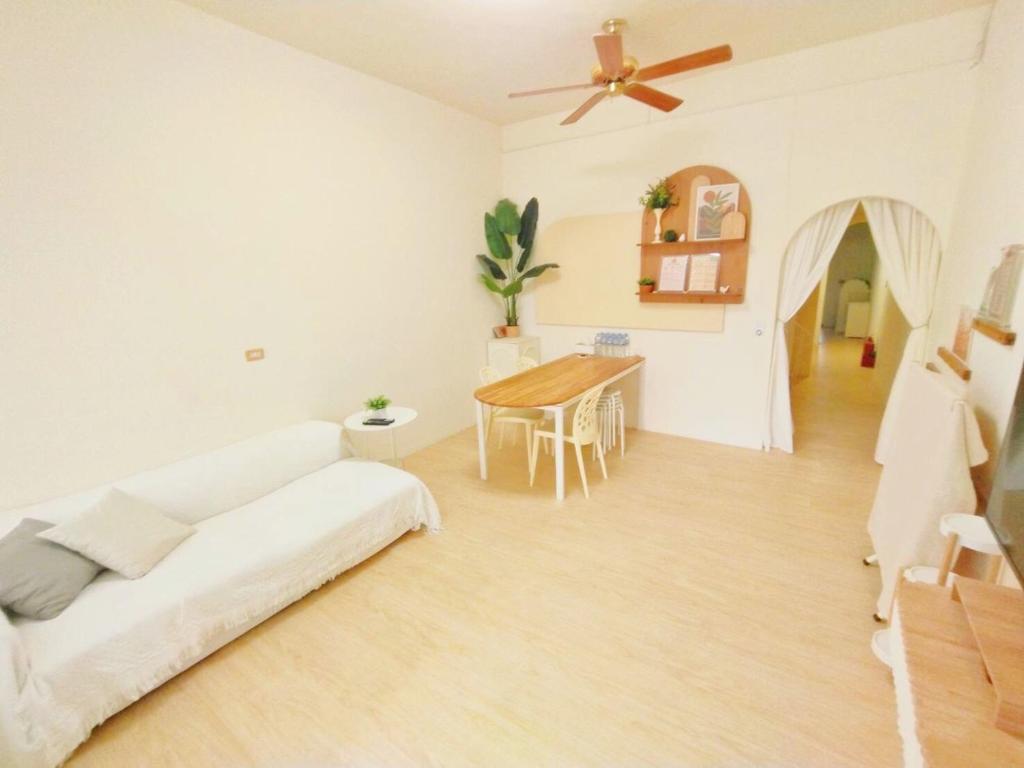 ein weißes Wohnzimmer mit einem Sofa und einem Tisch in der Unterkunft 清清長屋包棟民宿 Ding House in Altstadt von Hengchun