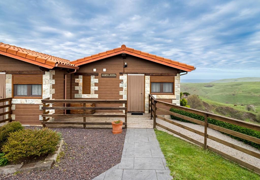 a wooden house with a gate and a fence at Apartamentos & Bungalows Ubiarco El Acebo by Alterhome in Ubiarco