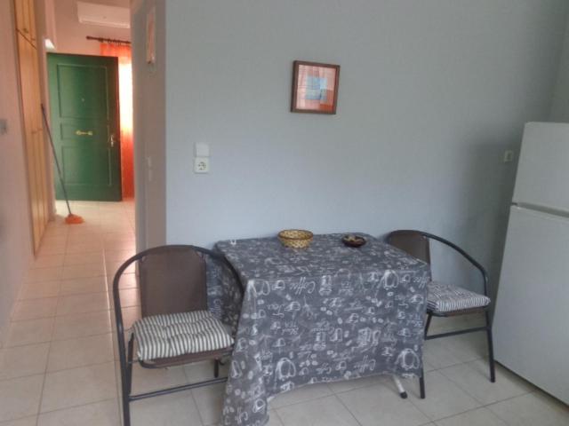 a table and chairs with a table and a refrigerator at vasia studios in Missolonghi