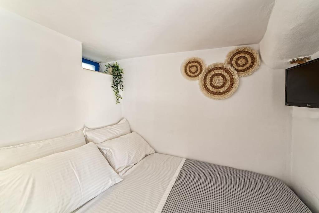Piccola camera con letto bianco e TV. di Cozy Cave Studio a Emporio