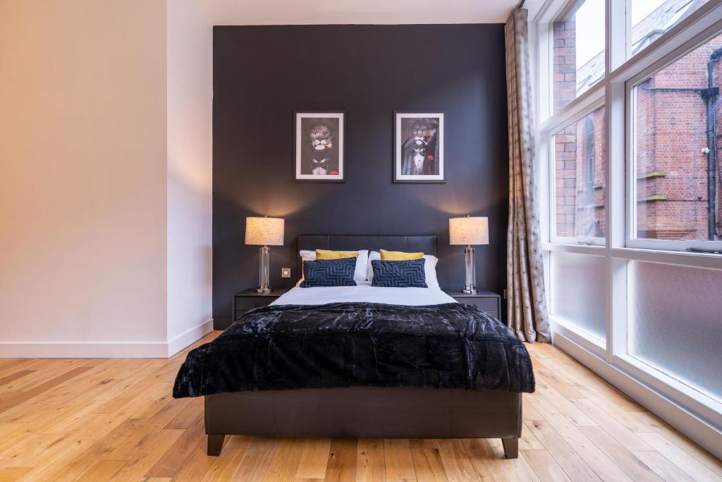 1 dormitorio con 1 cama con pared negra en Mandega House en Sheffield