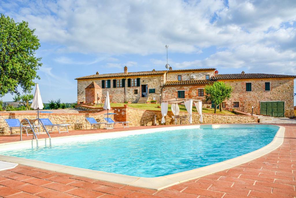 une maison avec une piscine en face d'un bâtiment dans l'établissement Santarcangelo Apartments - Happy Rentals, à Asciano