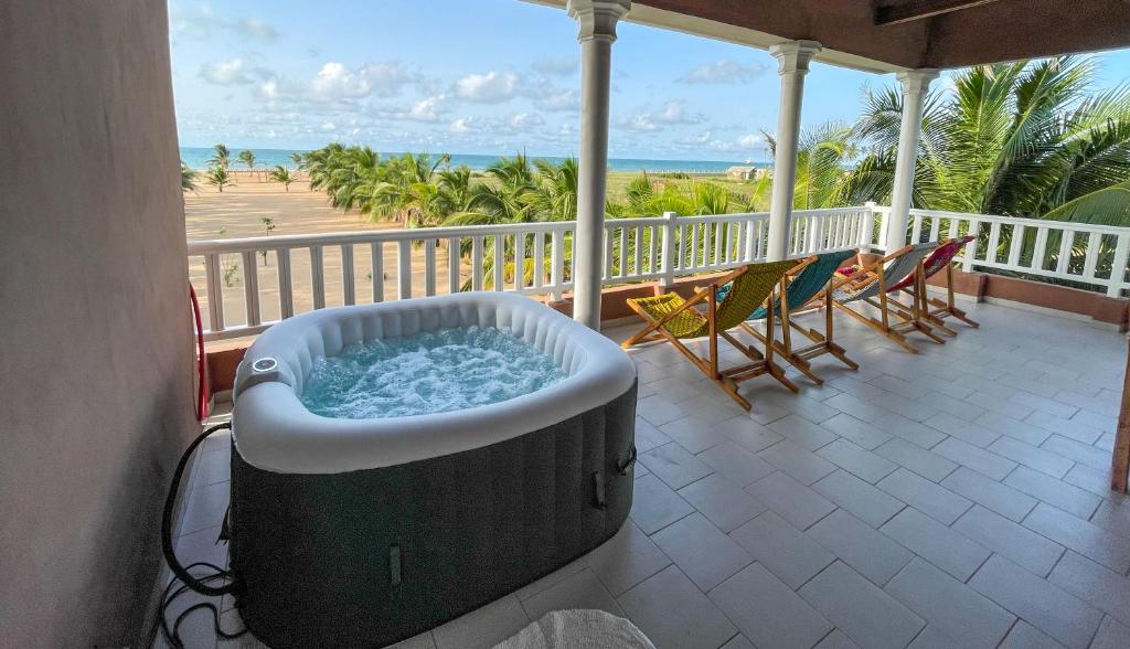 uma banheira de hidromassagem numa varanda com vista para a praia em Spacious and cozy beachfront villa em Grand-Popo