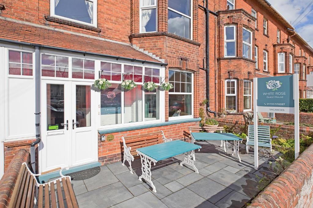 a brick building with two tables outside of it at White Rose Guest House in Filey