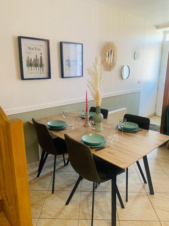 une salle à manger avec une table et des chaises en bois dans l'établissement La roseraie de L arguenon, appartement charmant centre ville, à Jugon Les Lacs