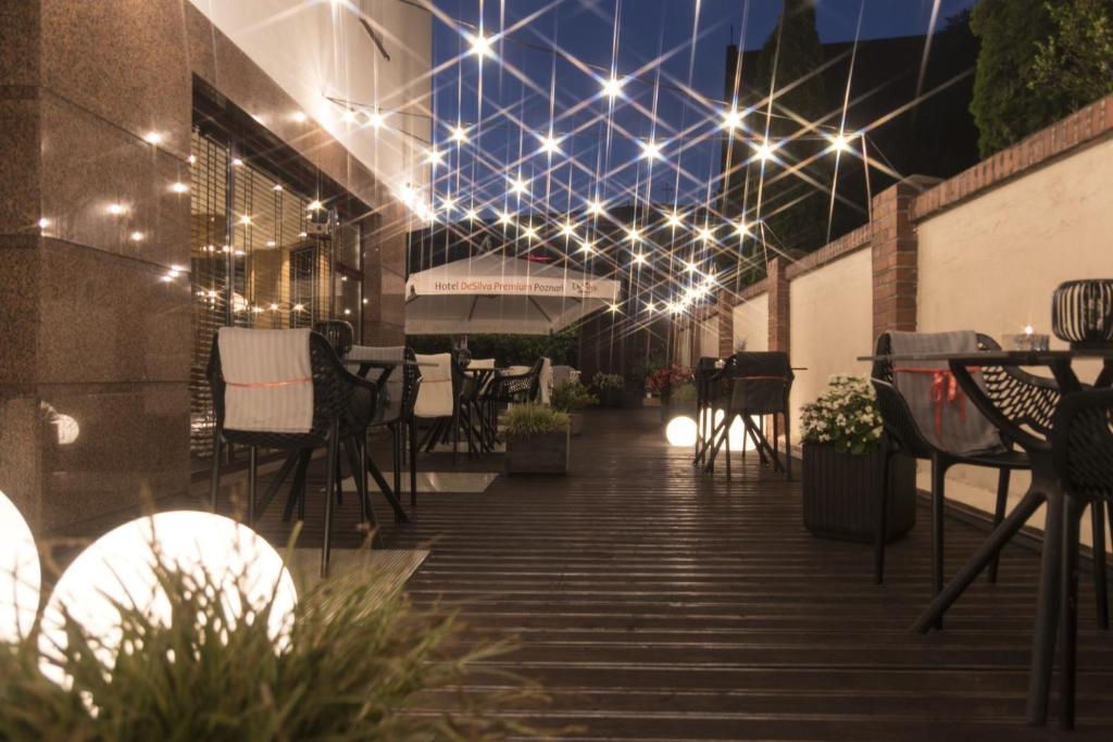 a patio with lights and tables and chairs at Hotel DeSilva Premium Poznań in Poznań