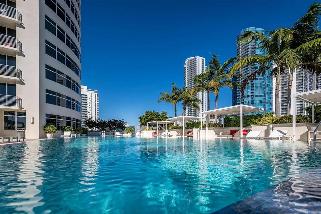 a large swimming pool with palm trees and buildings at 3 Story Luxury Apt Las Olas FTL in Fort Lauderdale