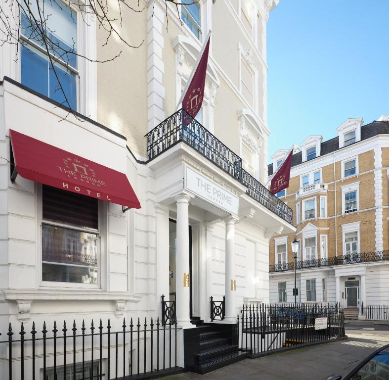 een wit gebouw met een rood bord erop bij The Prime London Hotel in Londen