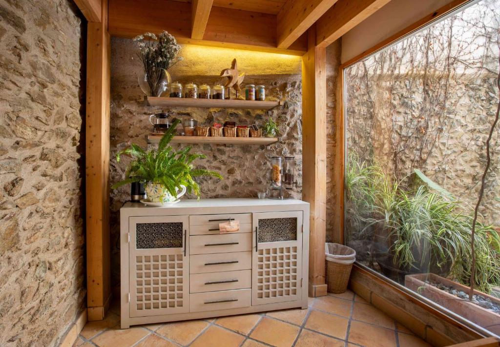 a porch with a heater and a window with plants at Hotel Boutique Niu de Sol - Designed for Adults in Palau-Saverdera