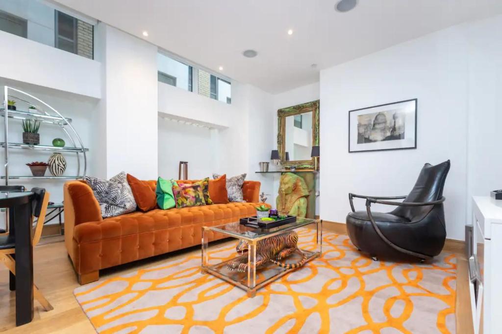 a living room with a couch and a chair at Luxurious 2 Bedroon Flat in the Heart of London in London