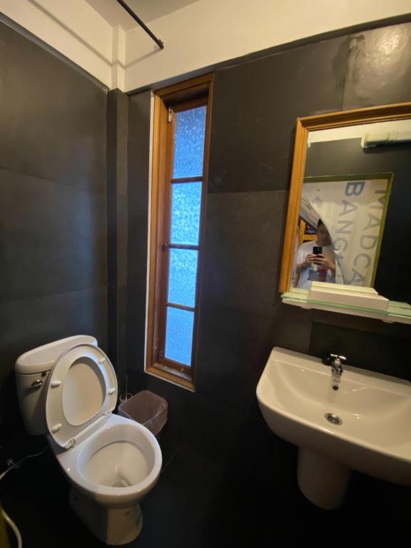 a bathroom with a toilet and a sink and a mirror at T-House BKK 2Floors near BTS with swimming pool and free Wifi in Klong Toi