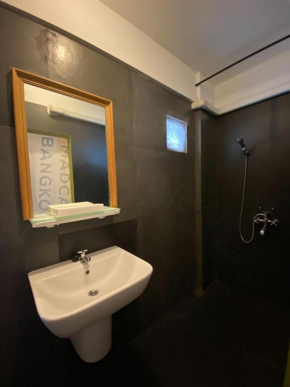 a bathroom with a sink and a mirror and a shower at T-House BKK 2Floors near BTS with swimming pool and free Wifi in Klong Toi