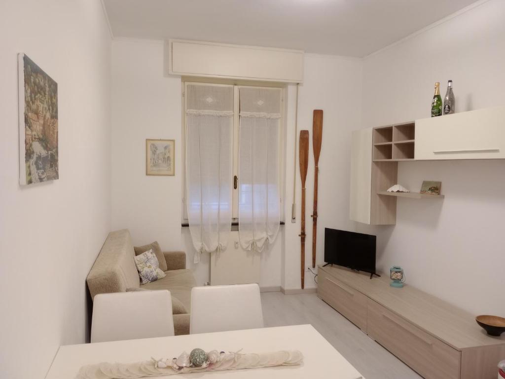 ein weißes Wohnzimmer mit einem Sofa und einem TV in der Unterkunft Casa Mariuccia in Santa Margherita Ligure