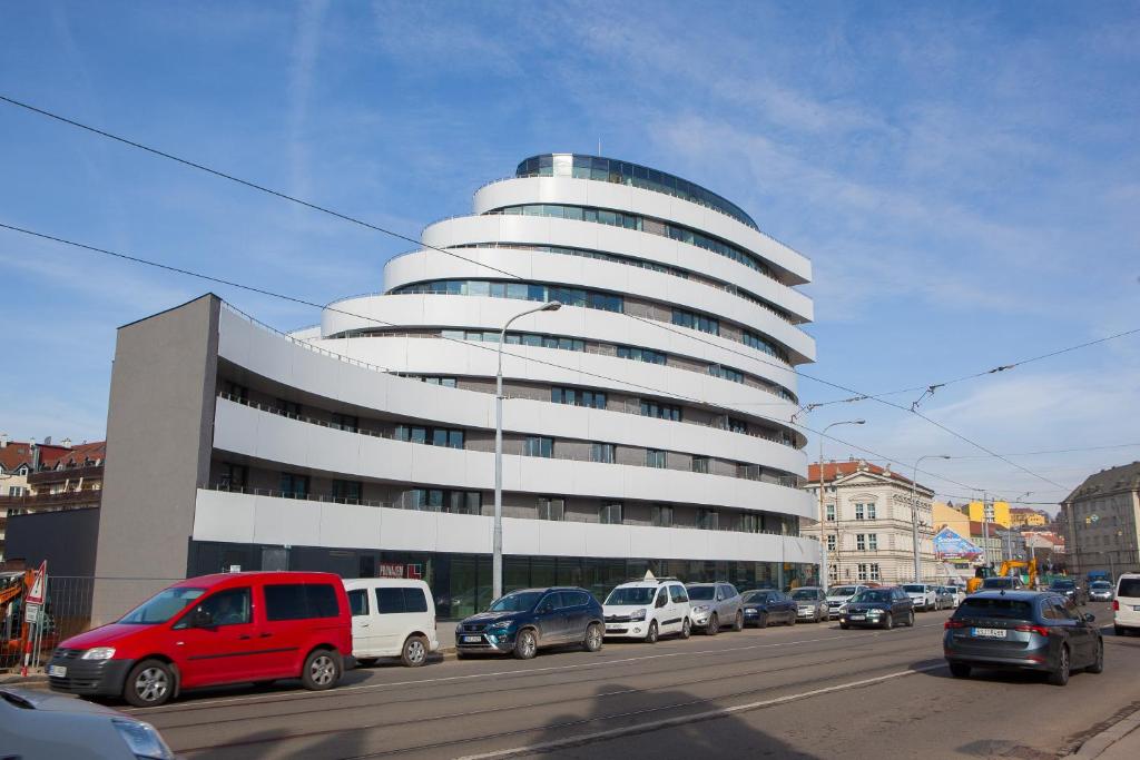 un gran edificio con coches estacionados frente a él en Apartmány Viviena en Brno