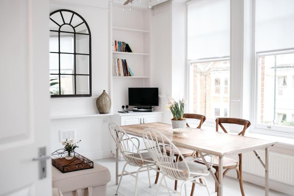 a white dining room with a table and chairs at 3 Bedroom House in Kew Gardens in Richmond