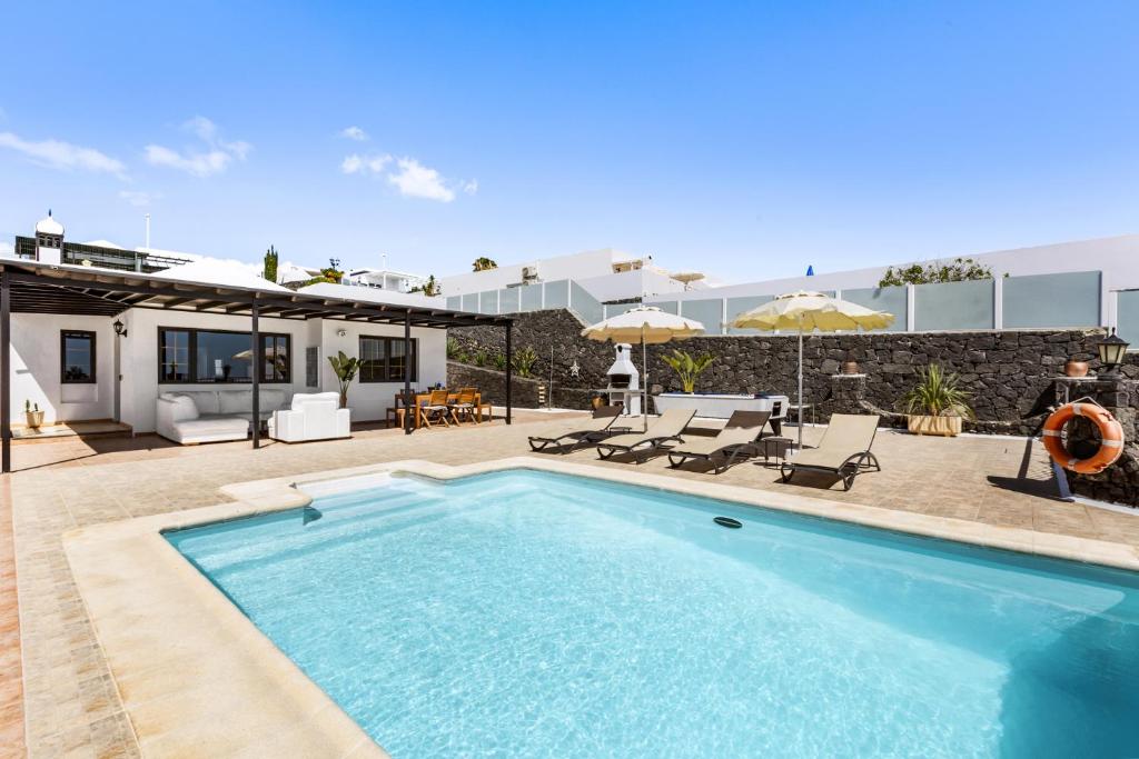 a swimming pool in front of a house at Villa 22 in Tías