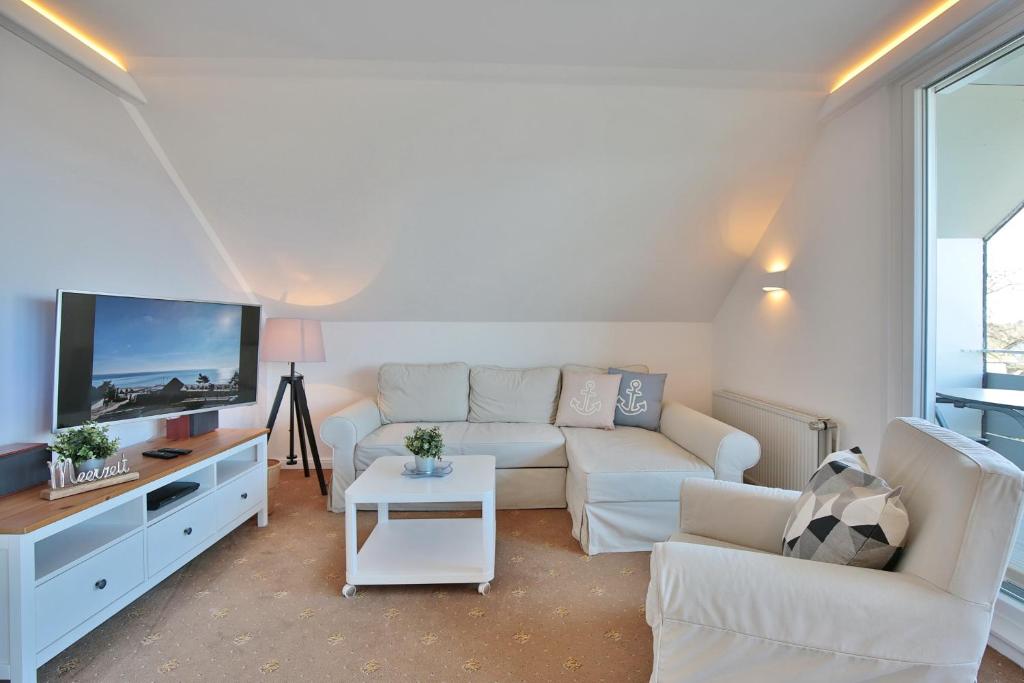 ein Wohnzimmer mit einem weißen Sofa und einem TV in der Unterkunft Appartemenhaus Linda-Lu Appartementhaus Linda-Lu Appartement 8 in Scharbeutz