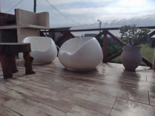 two white chairs sitting on top of a wooden deck at HUAYCAMAR in Playa Dorada