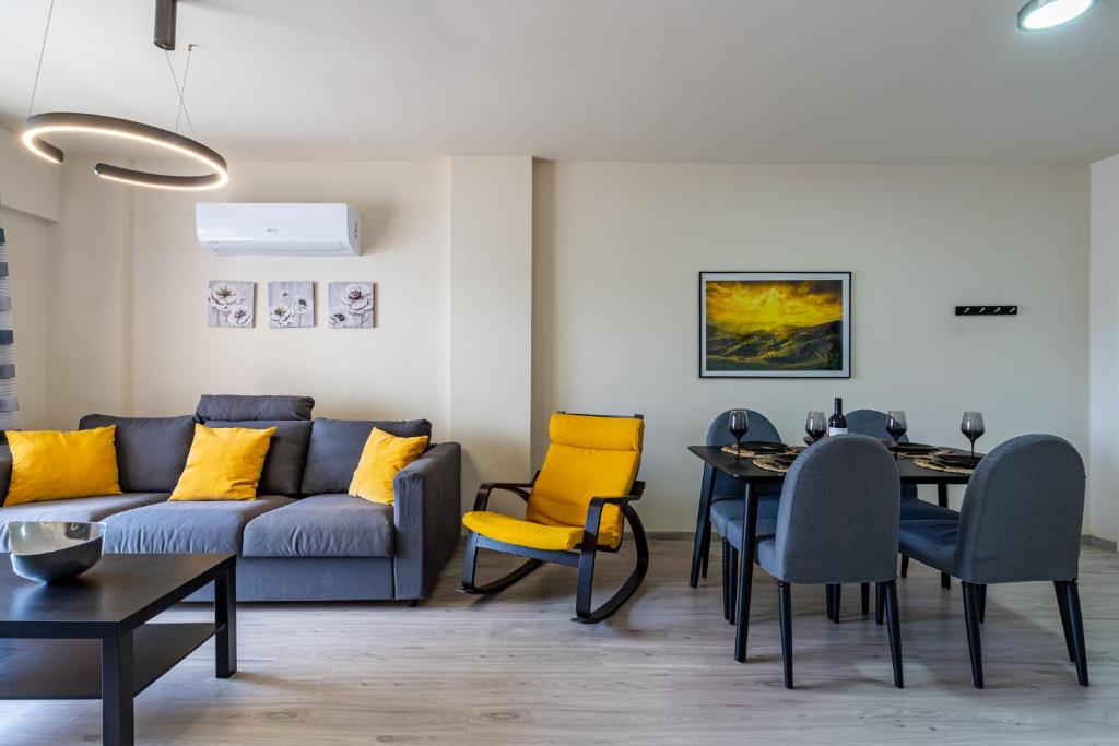 - un salon avec un canapé, une table et des chaises dans l'établissement Vox 2-Bedroom Apartment in Larnaca, à Larnaka