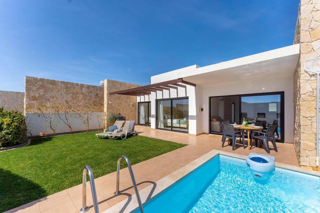 a villa with a swimming pool and a yard at Villa Hobie Cat in Sagres