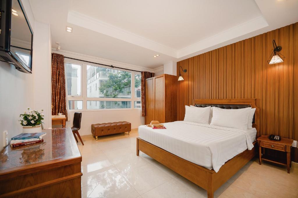 a bedroom with a bed and a desk and a window at Tuong Vy Ben Thanh Hotel - 40 Bui Thi Xuan in Ho Chi Minh City