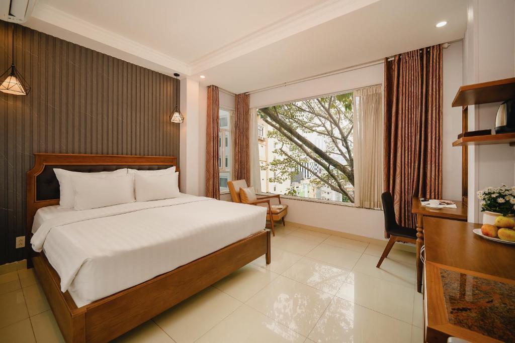 een slaapkamer met een bed en een groot raam bij Tuong Vy Ben Thanh Hotel in Ho Chi Minh-stad