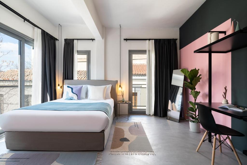 1 dormitorio con 1 cama, escritorio y ventanas en Play Psyri Athens en Athens