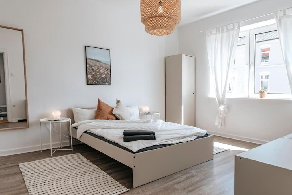 ein weißes Schlafzimmer mit einem Bett und einem Fenster in der Unterkunft City-Center App ZENTRAL, 24-7 Check-in in Kiel