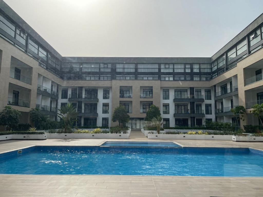 un grand bâtiment avec une piscine devant dans l'établissement Luxury Apartment - Embassy Gardens, à Accra