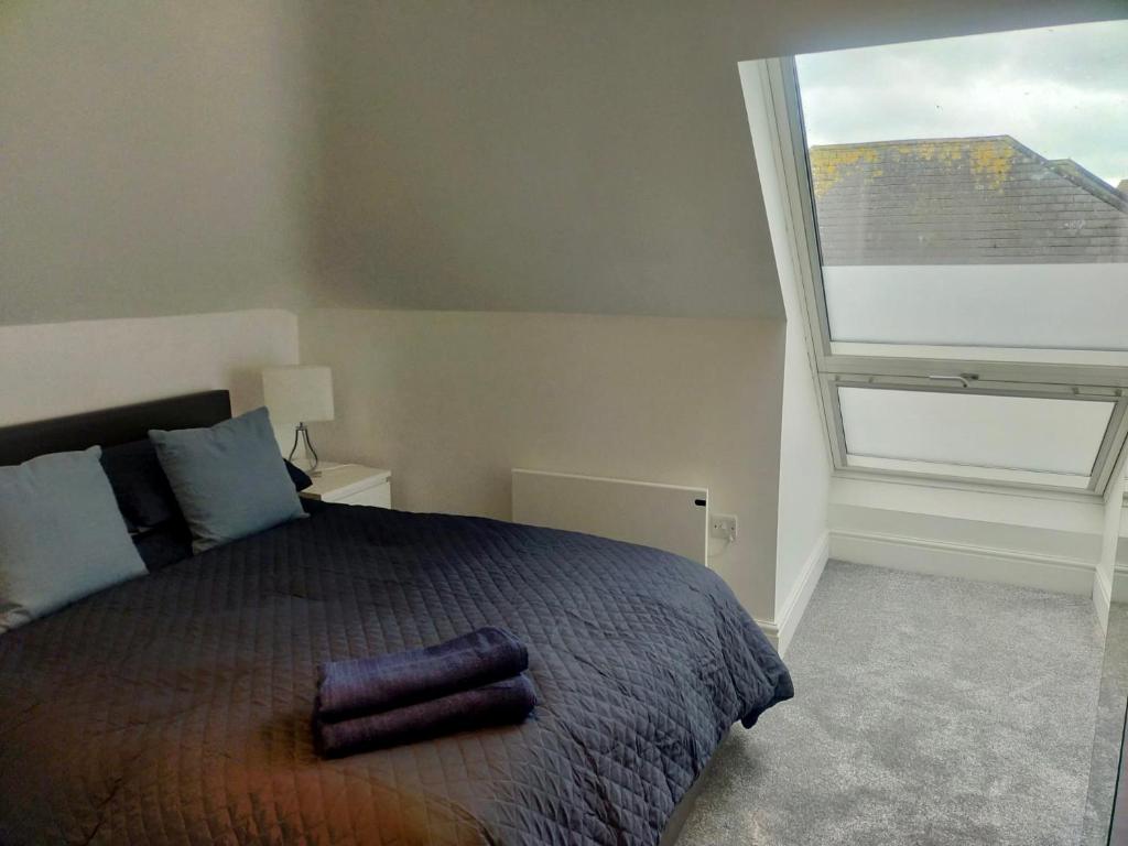 een slaapkamer met een groot bed en een groot raam bij Stunning Luminous Penthouse/ 2Beds 2Baths in Bournemouth
