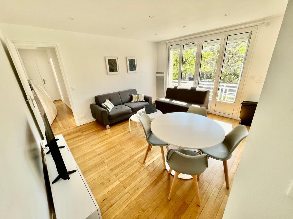 un salon avec une table et un canapé dans l'établissement Le triangle d'or Paris-CDG- Disney, à Vaires-sur-Marne