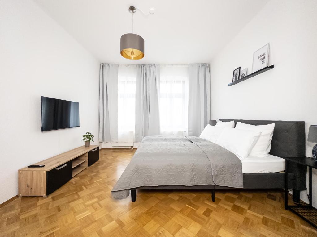 a bedroom with a bed and a flat screen tv at Moderne 3Zimmer Wohnung mit Netflix und Balkon in Leipzig