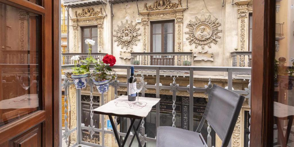 a table and chairs on a balcony with a building at Tu Casa En Granada ideal para tu familia in Granada