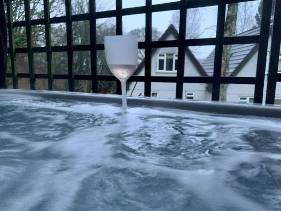 una copa de vino en una bañera de hidromasaje en 3 bed holiday home with hot tub Valley Lodge 32 en Gunnislake
