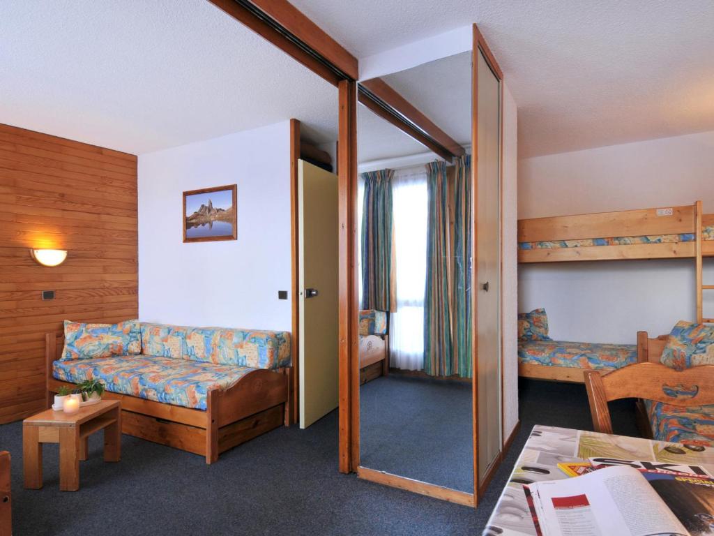 une chambre d'hôtel avec des lits superposés et un salon dans l'établissement Studio fonctionnel - au pied des pistes, casier à skis, animaux admis - FR-1-181-2181, à La Plagne Tarentaise
