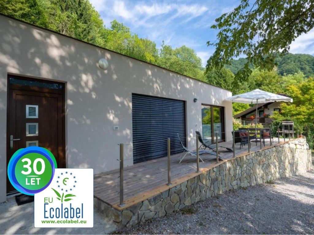 une maison avec une terrasse en bois devant elle dans l'établissement Nature View House with Sauna, à Tolmin