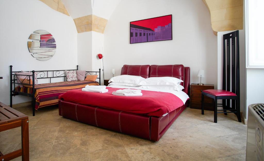 a bedroom with a large red bed and a couch at La Bella Lecce B&B in Lecce