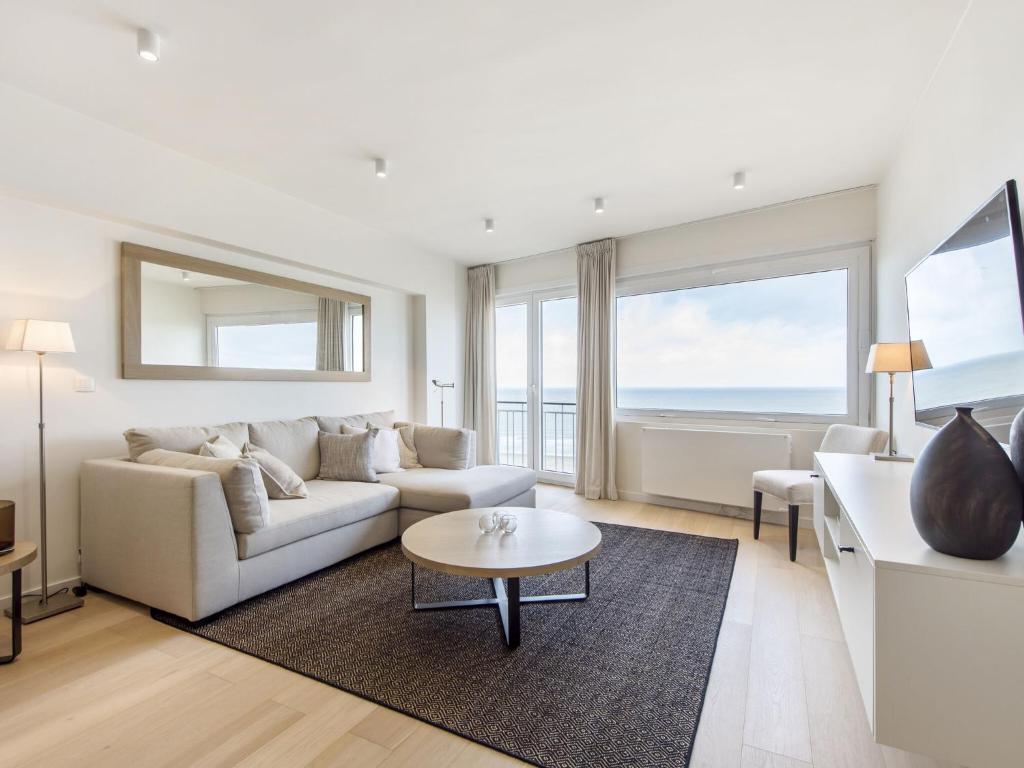 uma sala de estar com um sofá e uma mesa em Costa Brava - Appartement 4 bedrooms - floor 9 em Blankenberge