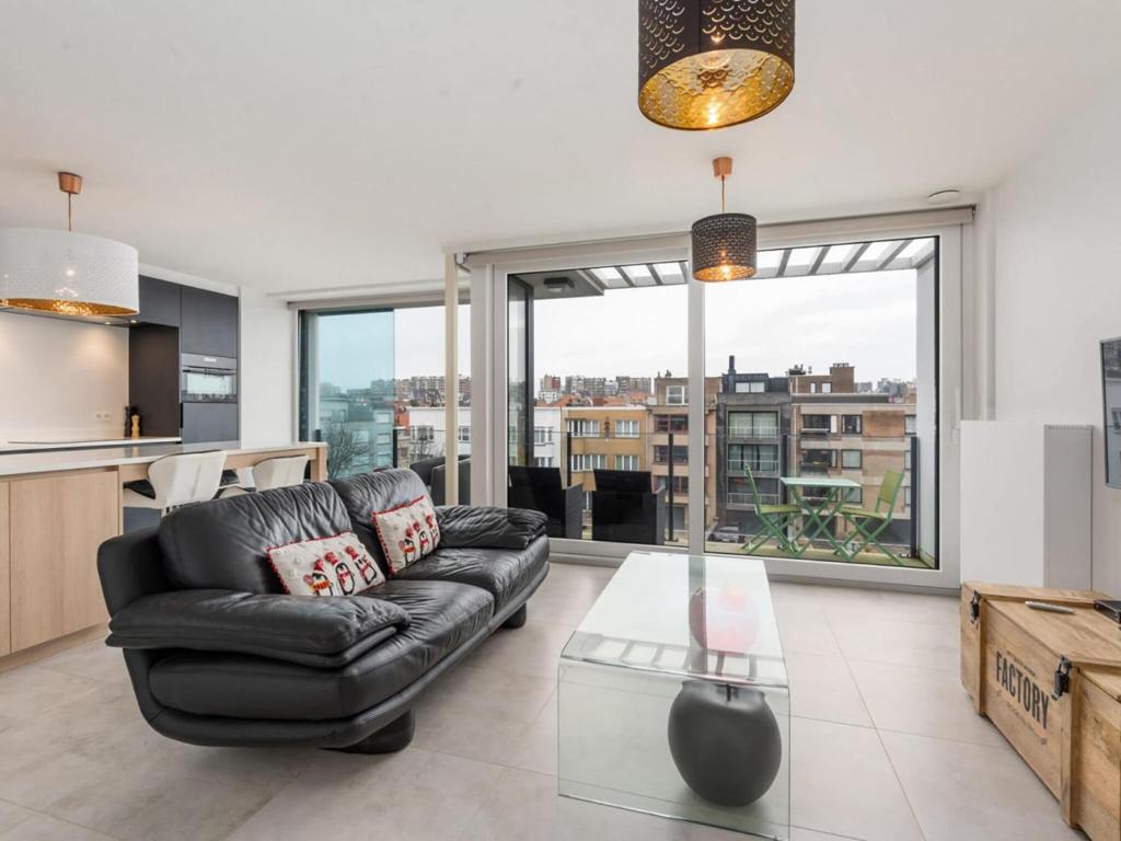 een woonkamer met een leren bank en een glazen tafel bij Castelli - Secundo 302 - Appartment 2 bedrooms garage - floor 3 in Blankenberge