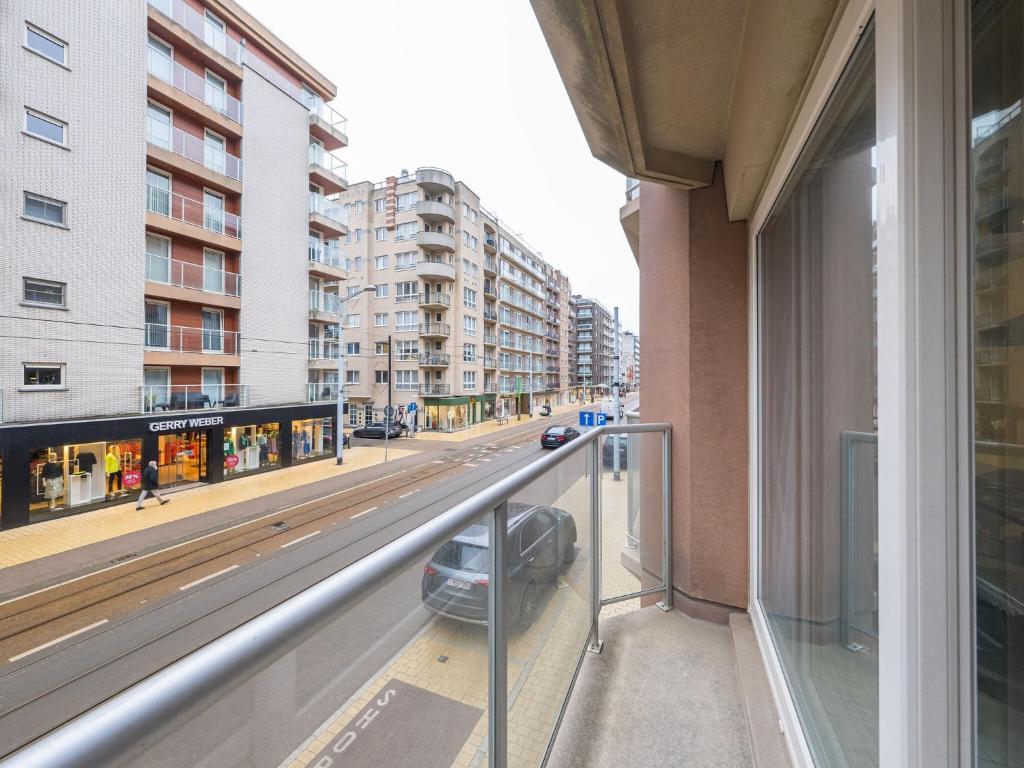 einen Balkon mit einem Auto, das auf einer Stadtstraße geparkt ist in der Unterkunft Appartment 2 bedrooms at De Ra 0101 on floor 1 in Middelkerke