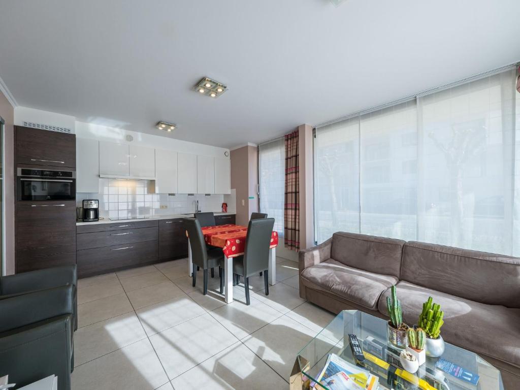 een woonkamer met een bank en een rode tafel bij Baros 0001 - Appartment 2 bedrooms - floor 0 in Middelkerke