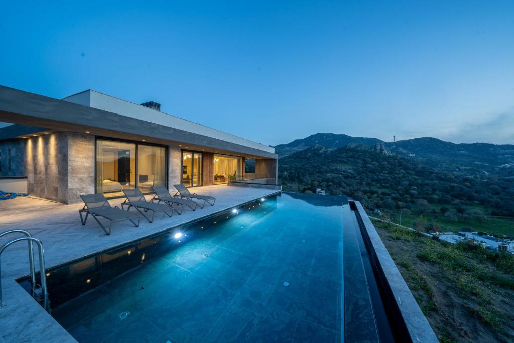 uma villa com piscina à noite em Hills Deluxe em Yalıkavak