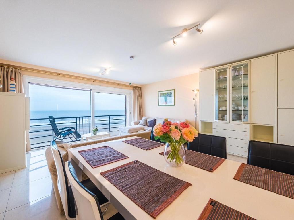 een eetkamer met een tafel en uitzicht op de oceaan bij Appartment 2 bedrooms with garage at Marianne I 0501 on floor 5 in Middelkerke