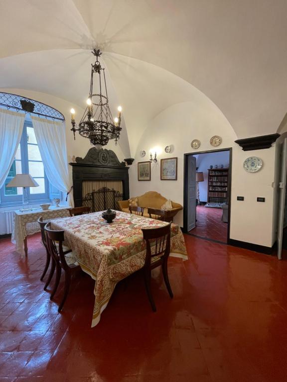 a dining room with a table and a chandelier at Bed & Breakfast Scià Dina in Toirano