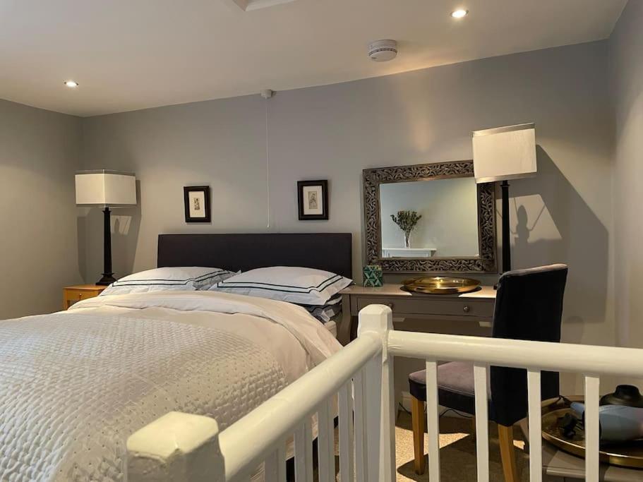 um quarto com uma cama, uma secretária e um espelho em St. John’s hill - with parking em Shrewsbury